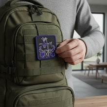 Load image into Gallery viewer, Melodia Gallery embroidered patch featuring a purple and white Columbine flower on a black background with a dark blue border.