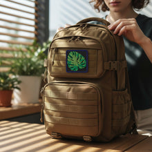 Load image into Gallery viewer, Melodia Gallery Monstera leaf embroidered tactical patch with hook and loop backing. Green leaf on black background with navy border.