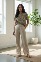 Load image into Gallery viewer, Melodia Gallery oversized cotton t-shirt with vintage art nouveau floral print in beige and black. Model wears it with light beige pants.