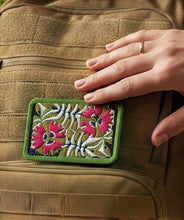 Load image into Gallery viewer, Melodia Gallery embroidered patch with pink passionflowers and green foliage on a tactical backpack.