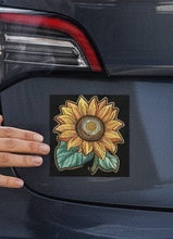 Load image into Gallery viewer, Melodia Gallery sunflower car magnet with vintage floral art design and green leaves on a black background.