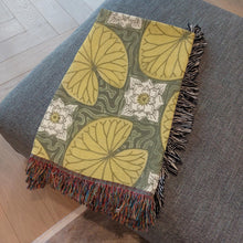 Load image into Gallery viewer, Melodia Gallery vintage woven cotton blanket with water lilies and lily pads in yellow, green, and white with colorful fringed edges.
