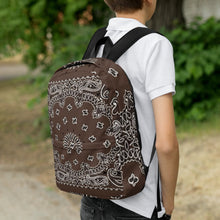Load image into Gallery viewer, Melodia Gallery brown bandana print polyester backpack with white paisley details. Features padded straps and multiple pockets.
