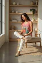 Load image into Gallery viewer, Melodia Gallery blush rose 100% cotton tank top with vintage firebird graphic print. Model sitting in chair reading.
