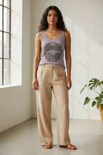 Load image into Gallery viewer, Melodia Gallery women's lilac cotton tank top with a vintage butterfly graphic print. Model wears tan linen pants.
