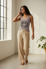 Load image into Gallery viewer, Melodia Gallery taupe 100% cotton tank top with vintage butterfly graphic print. Model wears tan linen pants.
