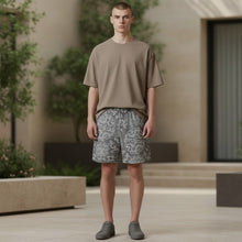 Load image into Gallery viewer, Melodia Gallery Men's Dragon Lotus recycled polyester blend swim trunks in grey with a white pattern, featuring an elastic waistband and pockets.
