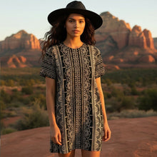 Load image into Gallery viewer, Melodia Gallery black and white lace-patterned cotton t-shirt dress with short sleeves and a black hat.

